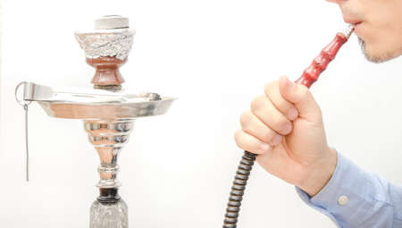Man smoking a shisha on a white isolated background suggesting turkish smokingの写真素材