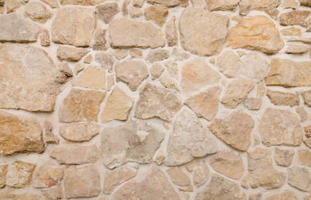 Ancient river stone wall texture with a warm lookの写真素材