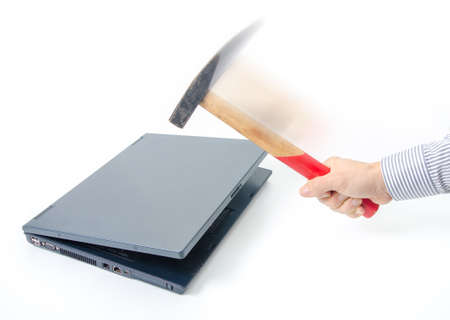 Destroying an old laptop suggesting data hack, old technology, slow computer, data protction and pc repairmanの写真素材