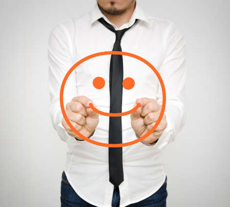 A happy face being drawn by a succesful businessman in a white shirtの写真素材
