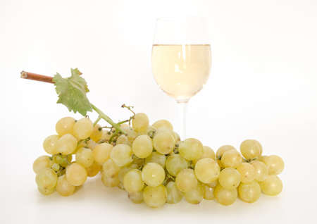 Yellow wine with grapes and vine leafの写真素材