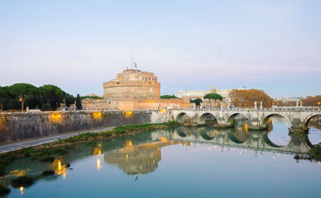 Rome, Italy - 1 December 2015: Castel Sant'Angelo, the Tiber River and the Aelius Pont Bridge on a warm sunset with lights all around and a blue sky. The castle of the pope and the bridge built by Hadrian.のeditorial素材