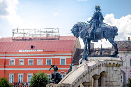 Matei Corvin ( Matthias Crovinus Rex ) statue monument in Unirii central Square in Cluj Napoca city, Transylvania region of Romania with the Josika Palace and Wass Palace on the backgroundのeditorial素材