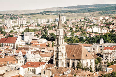 Saint Michael Catholic Gothic Church in Unirii Square and old historic medieval center of Cluj-Napoca with a vintage look. Soft filters and garin effects applied for an old lookの写真素材
