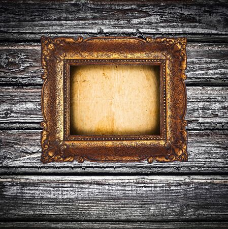 Antique golden frame over wooden wallの写真素材
