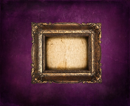 Empty golden frame on purple grunge wallの写真素材