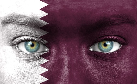 Human face painted with flag of Qatarの写真素材