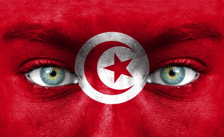 Human face painted with flag of Tunisiaの写真素材