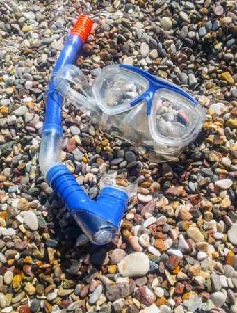 Diving mask and tube on pebble stoneの写真素材