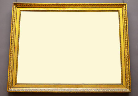 Empty golden picture frame hanging on wall