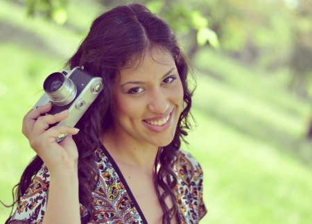 Retro image of beautiful woman holding vintage cameraの写真素材