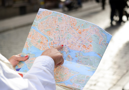 Tourist hand pointing at City mapの写真素材