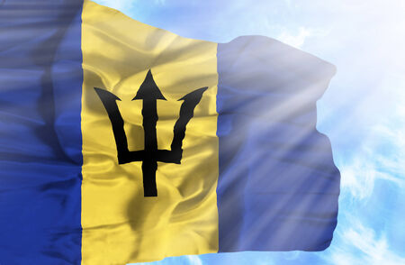 Barbados waving flag against blue sky with sunraysの写真素材