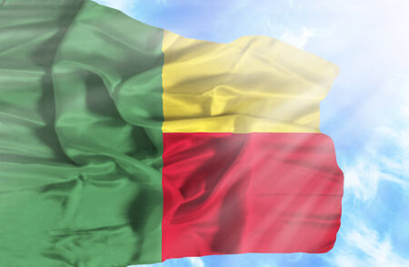 Benin waving flag against blue sky with sunraysの写真素材