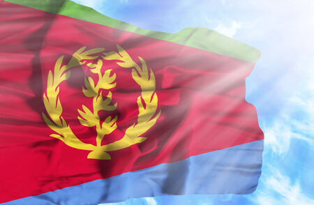 Eritrea waving flag against blue sky with sunraysの写真素材