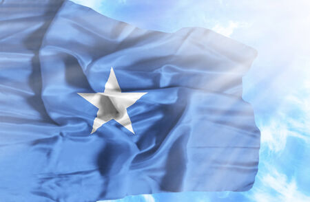 Somalia waving flag against blue sky with sunraysの写真素材