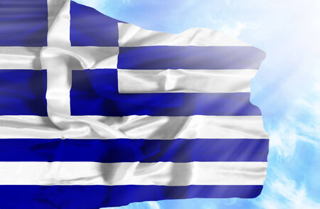 Greece waving flag against blue sky with sunraysの写真素材