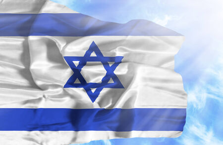 Israel waving flag against blue sky with sunraysの写真素材