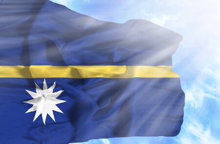 Nauru waving flag against blue sky with sunraysの写真素材