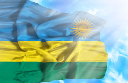 Rwanda waving flag against blue sky with sunraysの写真素材