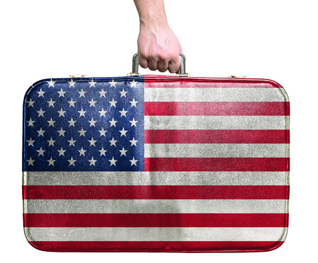 Tourist hand holding vintage leather travel bag with flag of United States of Americaの写真素材