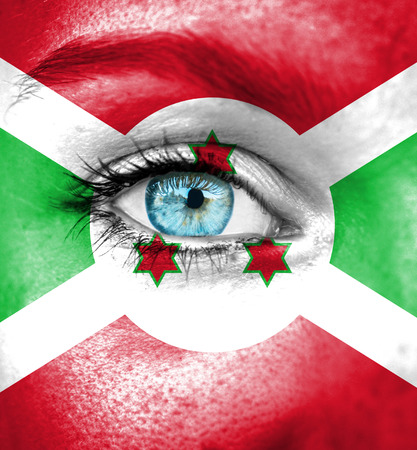 Woman face painted with flag of Burundiの写真素材