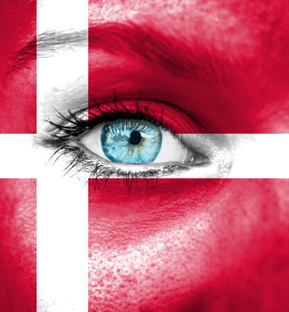 Woman face painted with flag of Denmarkの写真素材