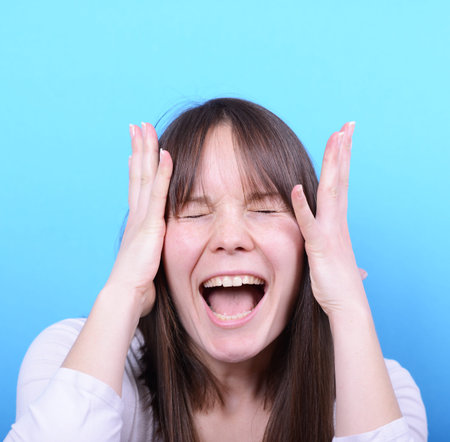 Portrait of girl screaming against blue background