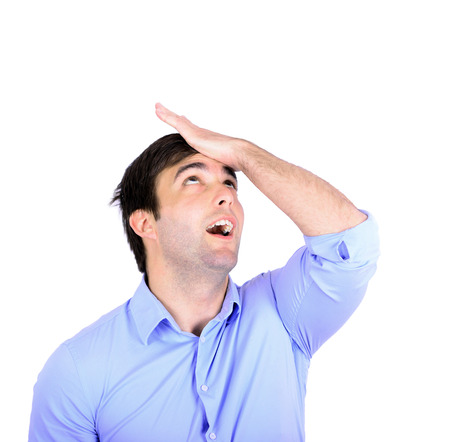 Portrait of young businessman slapping hand on head having a duh momentの写真素材