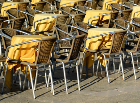 Street view of a coffee terrace with tables and chairsの写真素材