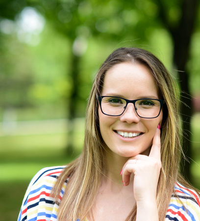 Portrait charming young woman glasses smiling background summer natureの写真素材