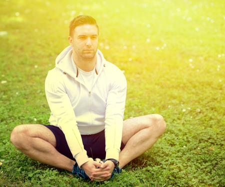 Handsome sportsman stretching outdoorsの写真素材