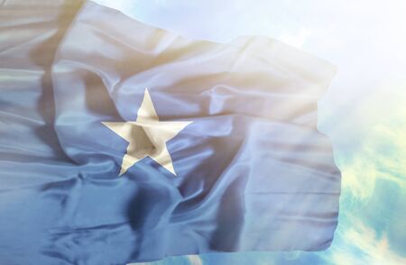 Somalia waving flag against blue sky with sunraysの写真素材
