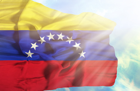 Venezuela waving flag against blue sky with sunraysの写真素材