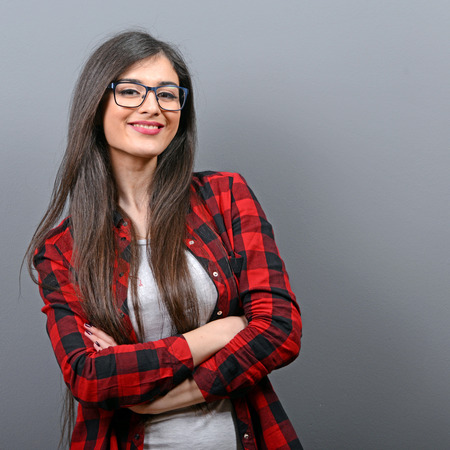 Portrait of beautiful casual woman against gray backgroundの写真素材