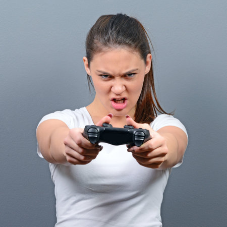 Portrait of woman playing video games against gray background