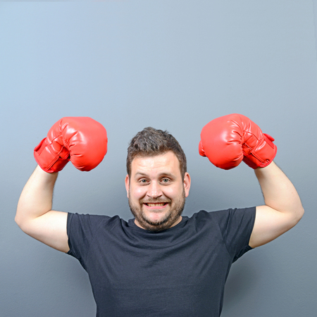 Portrait of chubby boxer posing with boxing gloves as a championの写真素材