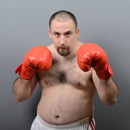 Portrait of funny fat boxer against gray backgroundの写真素材