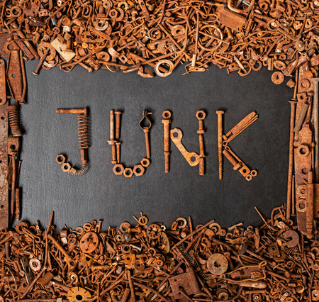 JUNK made with rusty screws and bolts on black board with frame consisted of junk metalの写真素材