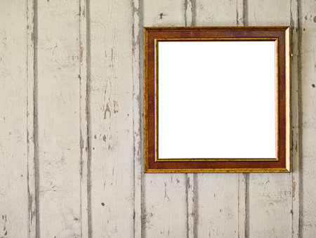 Empty photo frame hanging on wooden wall