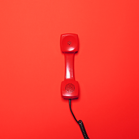 Retro red telephone tube on red background - Flat layの写真素材