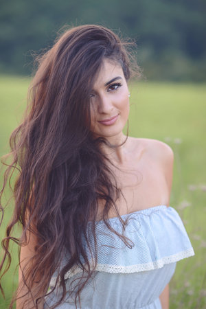 Portrait of beautiful young woman with lon hair enjoying nature