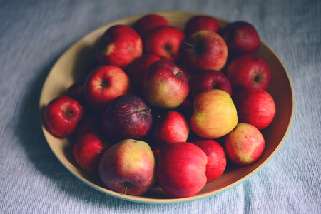 Pile of fresh apples in wooden bowl in living room - Farm food conceptの写真素材