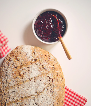 Home made bread with raspberry jam and coffee cup - Flat layの写真素材