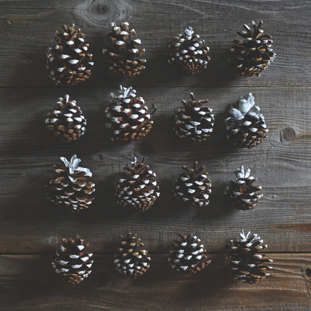 Flat lay of Christmas decorated pincones on wooden background - Trendy minimal flat lay designの写真素材
