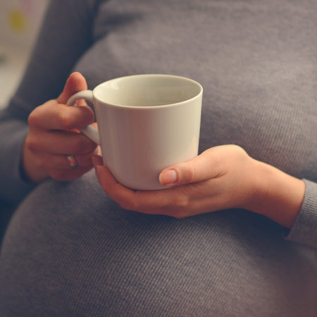 Pregnant woman enjoying cup of coffeeの写真素材