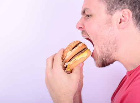 Man eating burger - Unhealthy food conceptual photoの写真素材