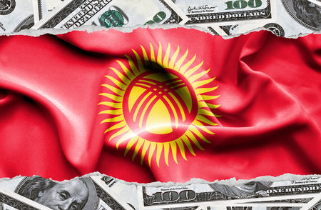 Financial concept with banknotes of US currency around national flag of Kyrgyzstanの写真素材