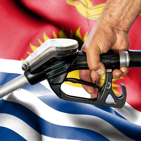 Gasoline consumption concept - Hand holding hose against flag of Kiribatiの写真素材