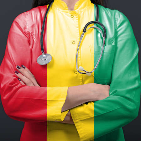 Doctor representing healthcare system with National flag of Guineaの写真素材
